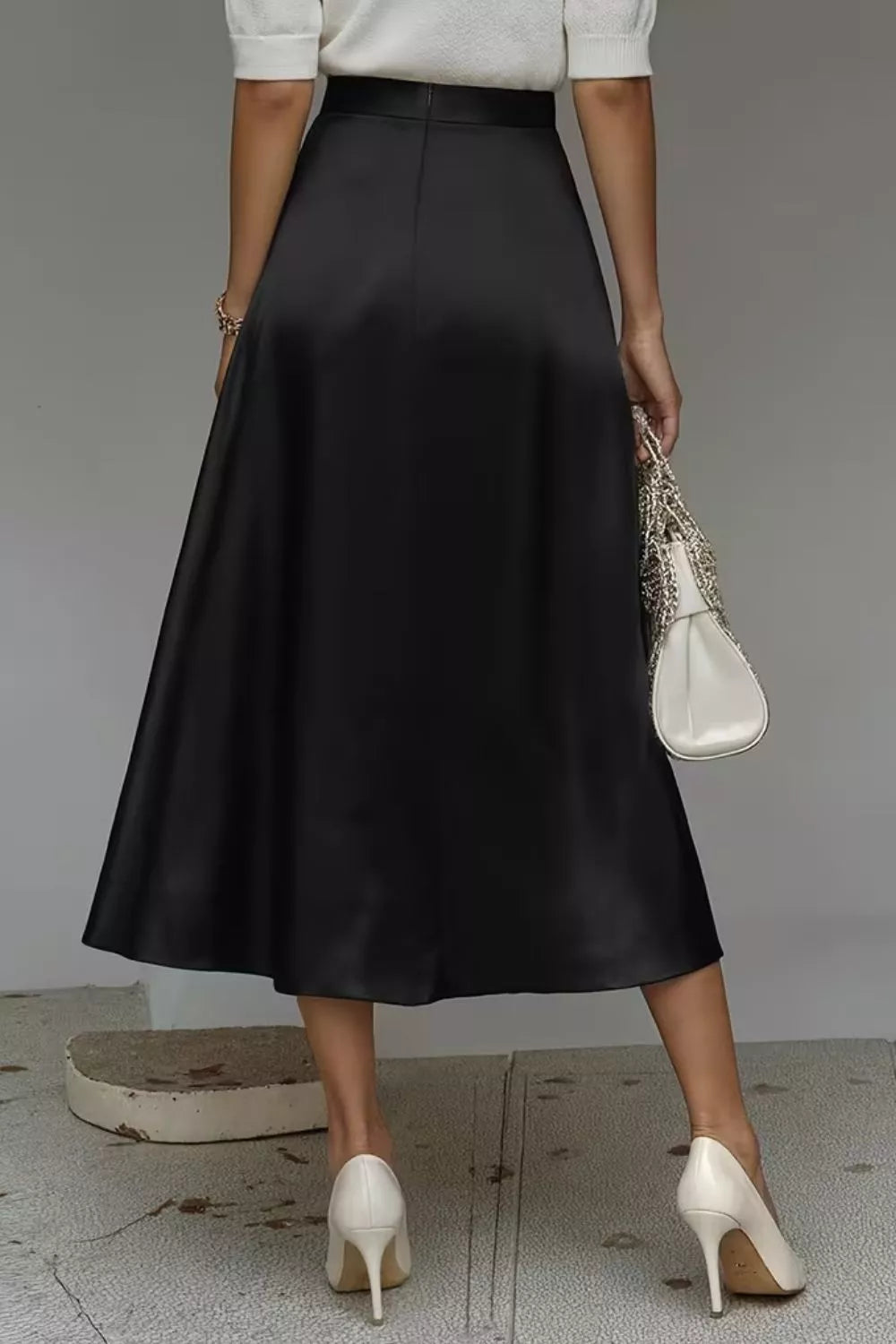 Black satin A-line midi skirt with side pockets, full flare and flowing silhouette