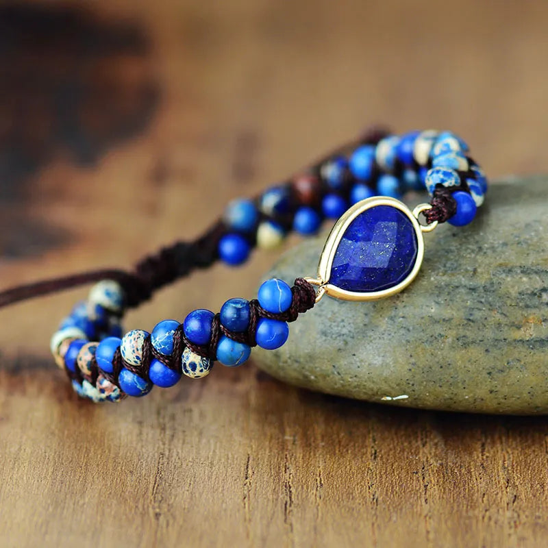 Blue beaded bracelet featuring teardrop dark blue stone in gold-tone bezel