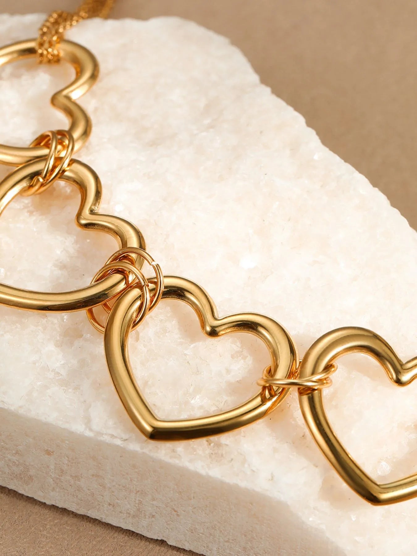 Gold-plated heart link necklace close-up of connected heart charms