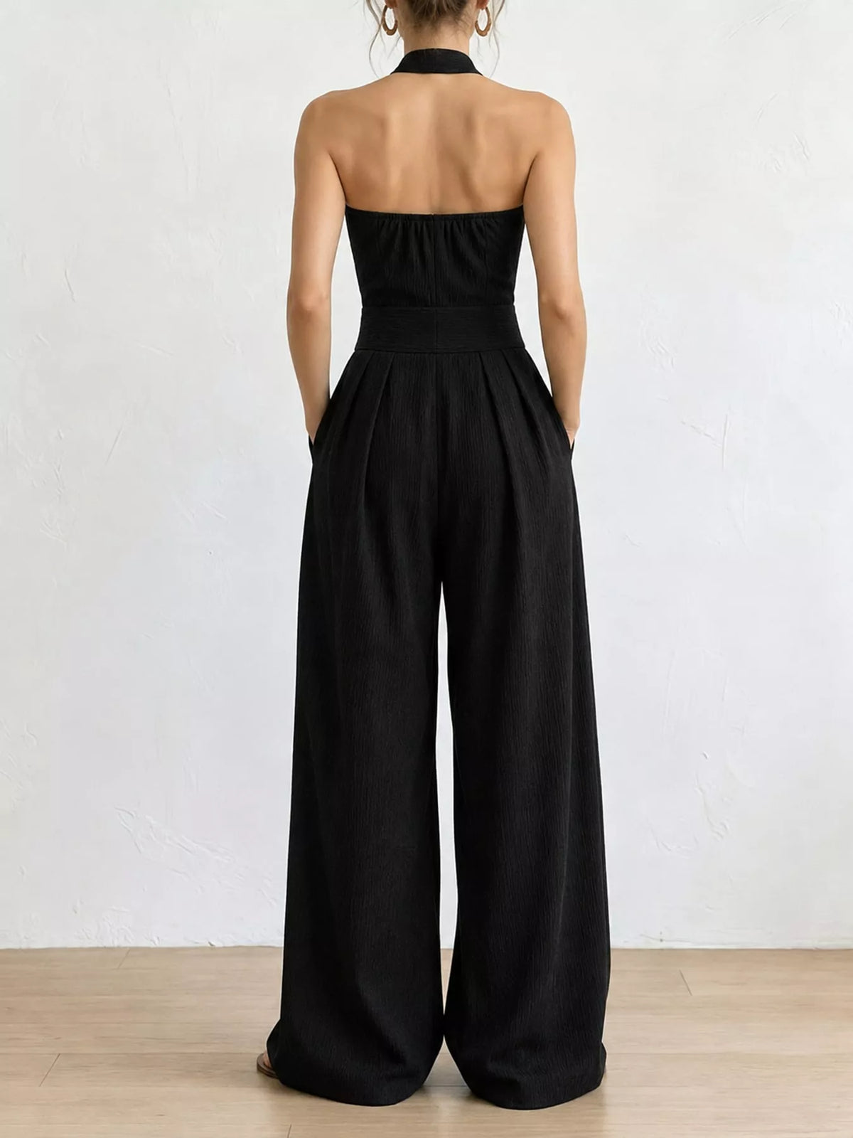 Black linen halter wide-leg jumpsuit back view with open halter strap and wide legs