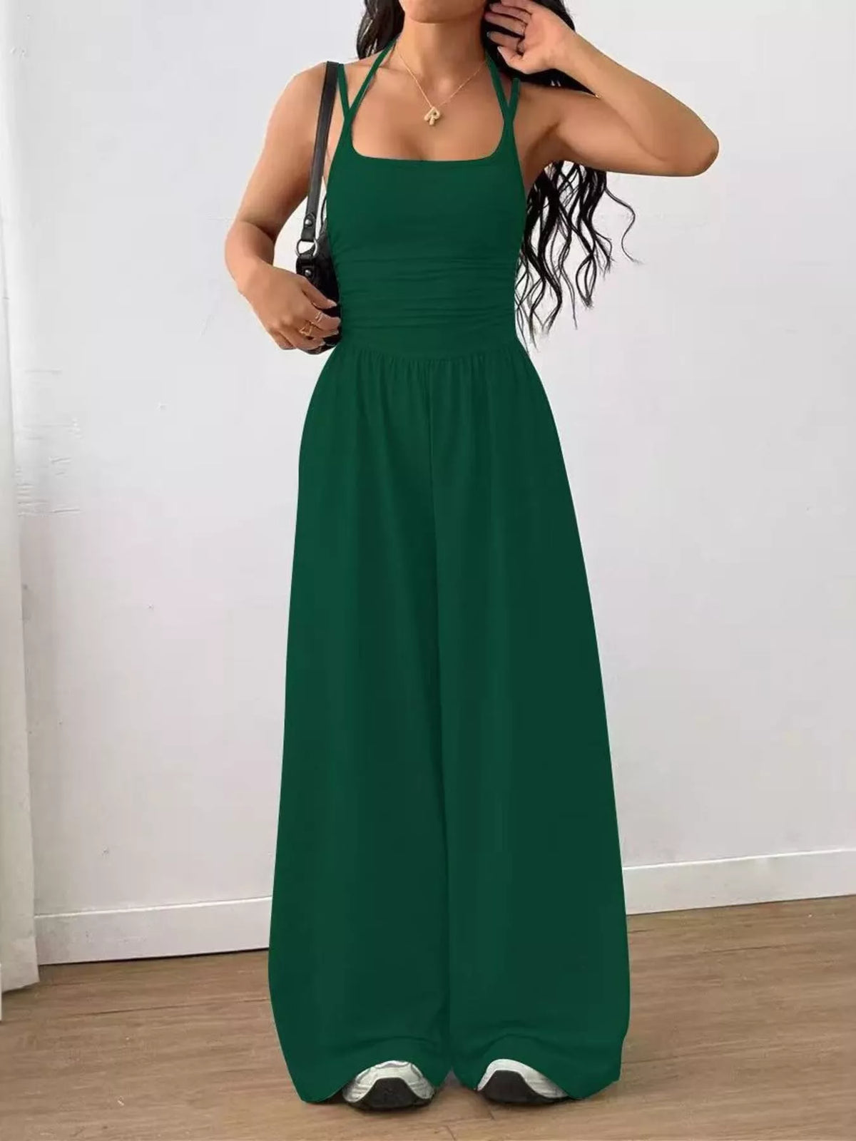Dark green spaghetti strap wide-leg jumpsuit with smocked waist and relaxed wide-leg cut