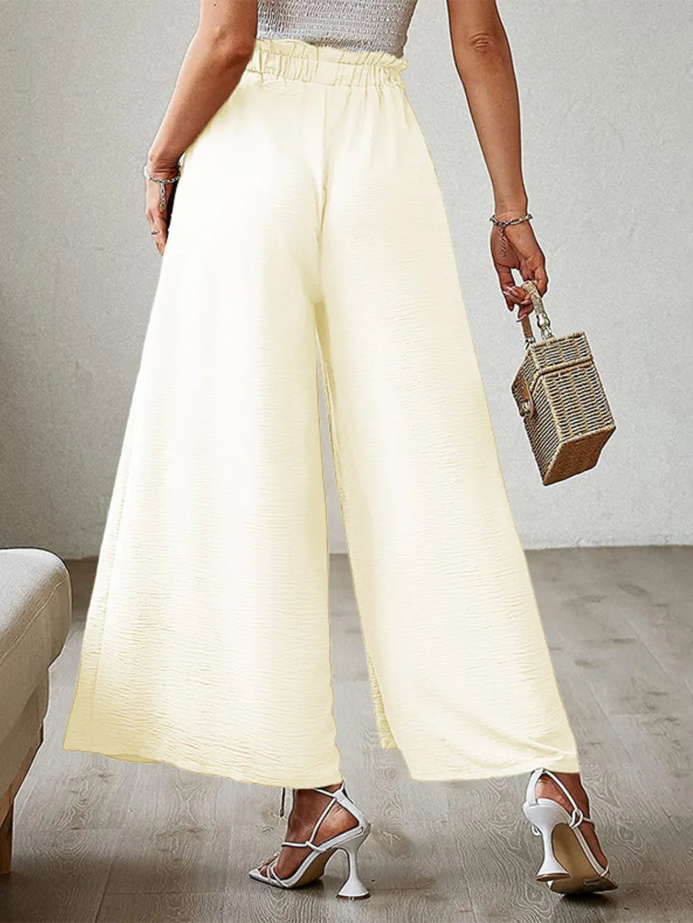 Pastel yellow tied-waist wide-leg pants with elastic waistband and flared legs