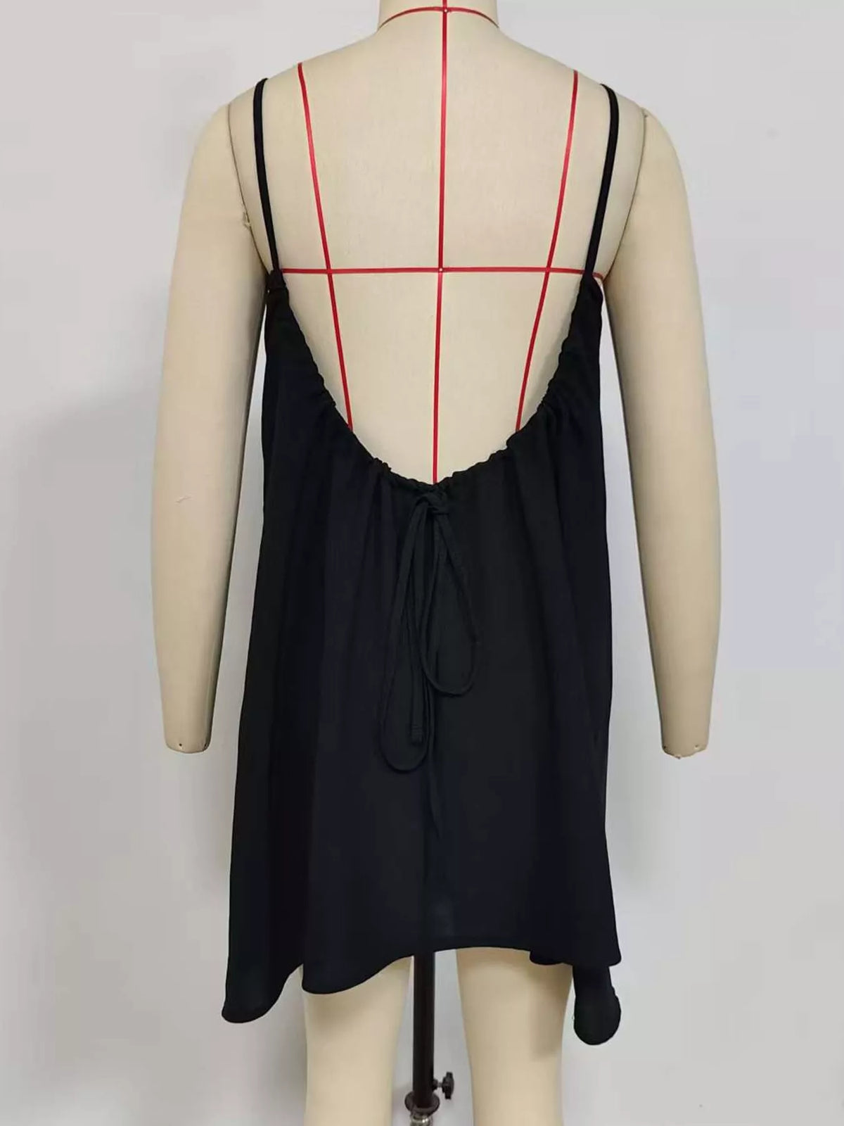 Black backless mini dress with deep scoop back and centered tie at the open back