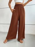 Wide-leg pants with pockets, dark brown textured fabric, elastic waistband.
