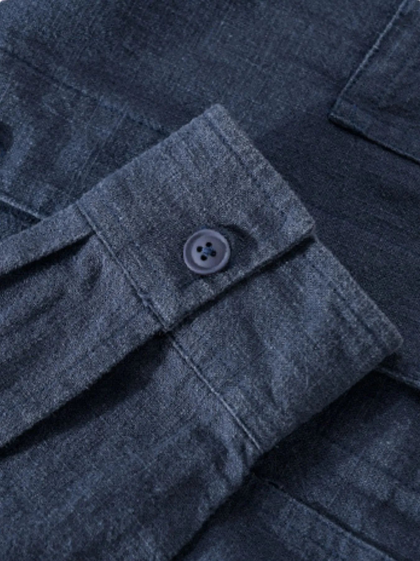 Dark blue button-up shirt close-up of button placket and chest pocket flap.