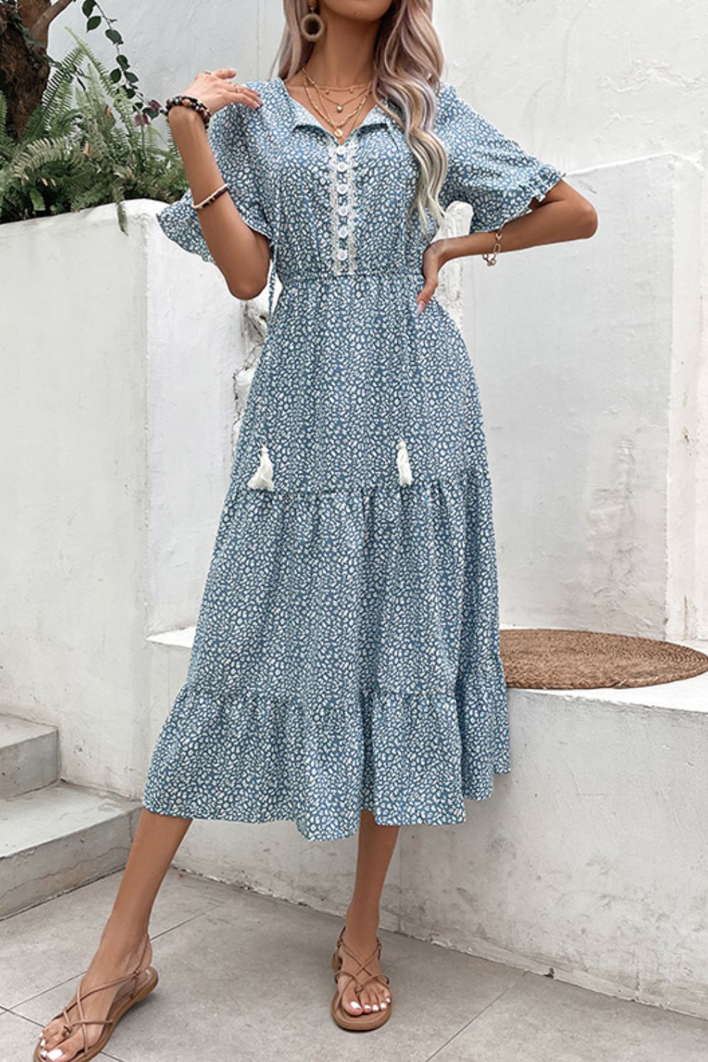 Light blue printed dress with button front, tassel ties, and tiered flounce skirt