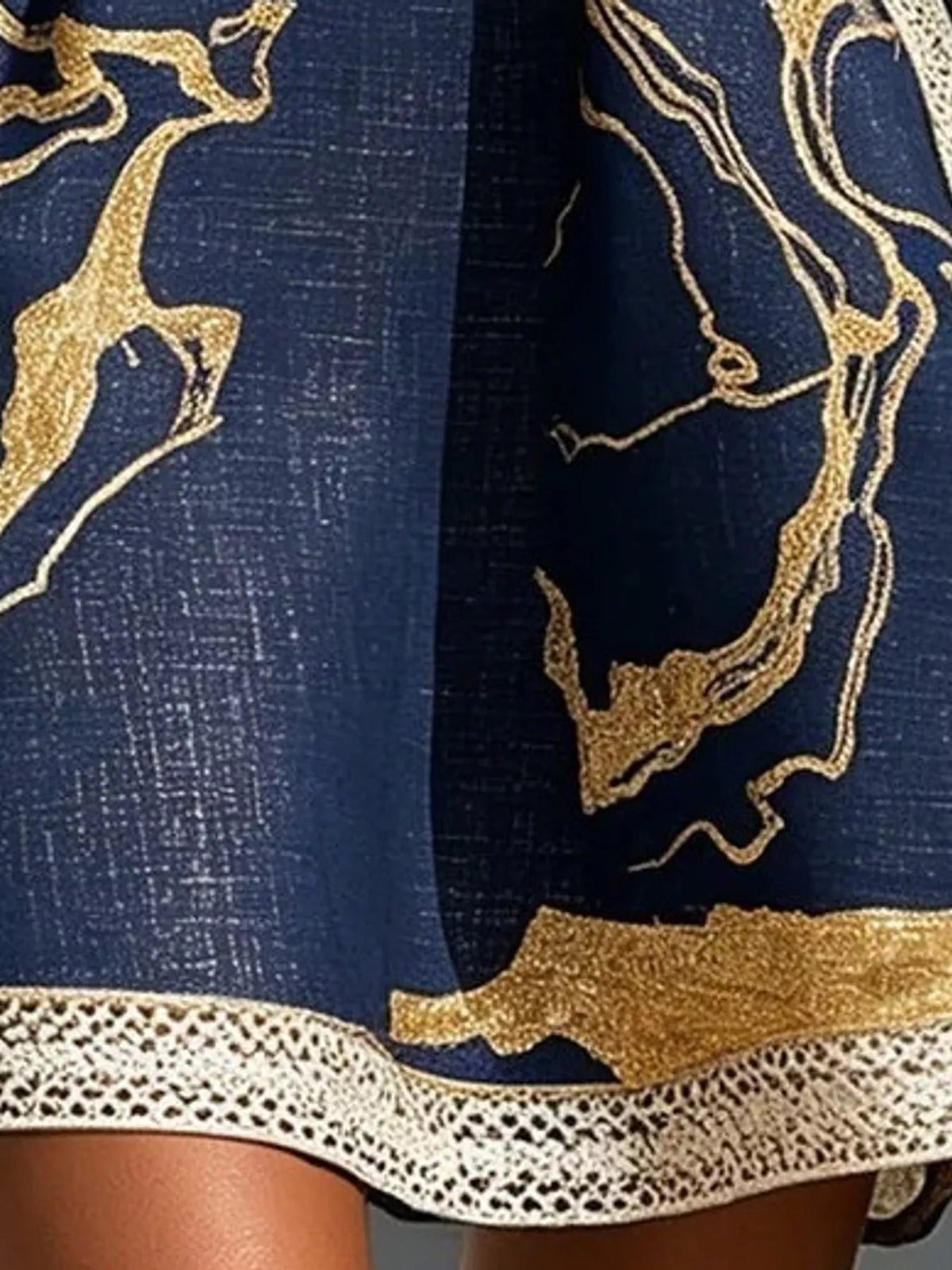 Navy mini dress close-up of gold abstract print and lace-trim hem