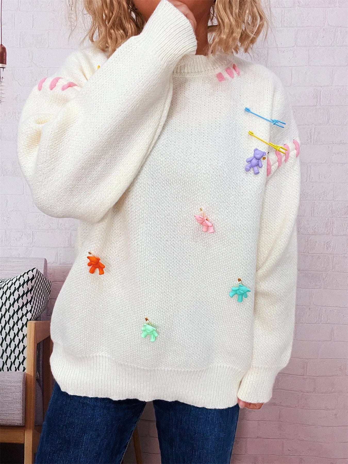 Cream round-neck sweater with multicolor bear appliques and ribbed cuffs
