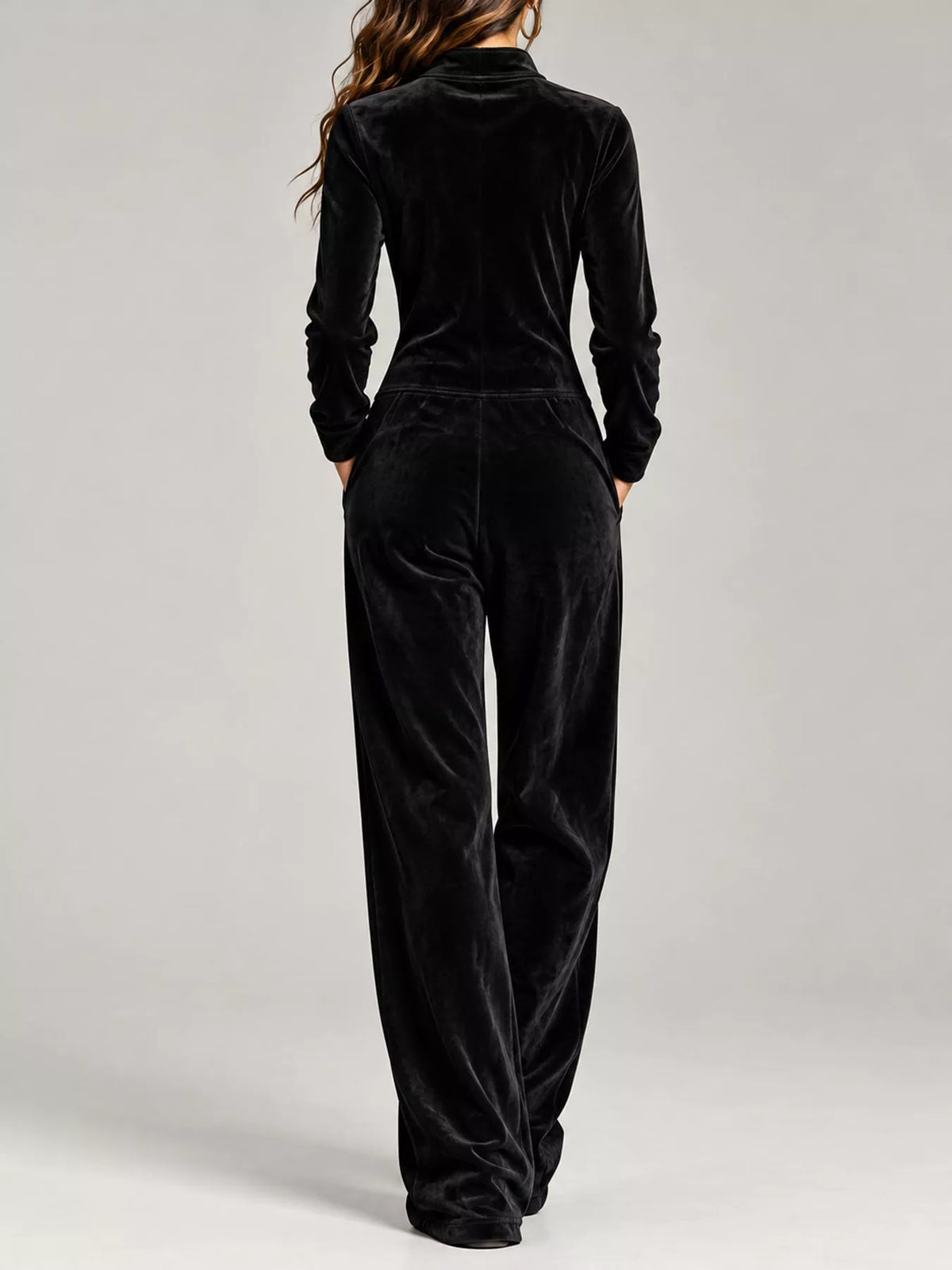Black velour zip-up jumpsuit with pockets and long sleeves, full-length back view