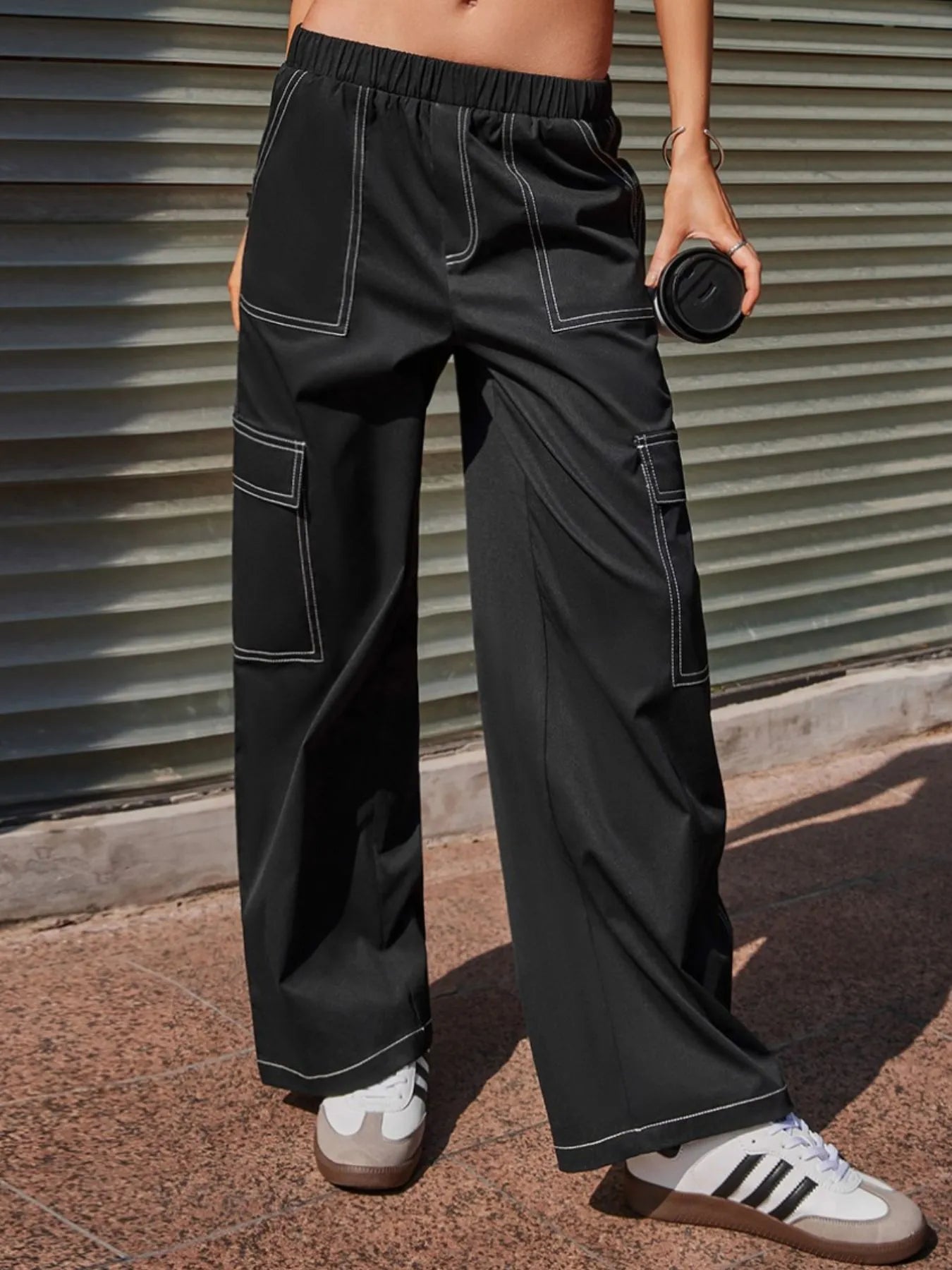 Black wide-leg pants with elastic waist, contrast-stitched pocket panels, and relaxed fit