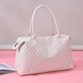 Dusty pink quilted travel bag with top handles, side pulls, and zip closure