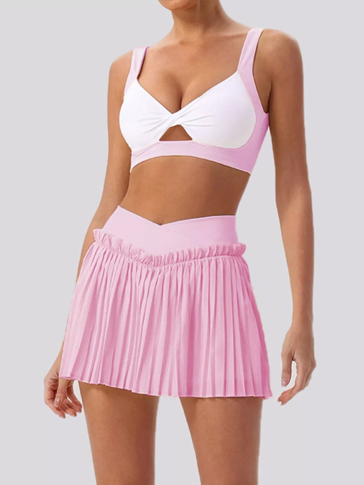 Two-piece set: sleeveless twist bra top and pleated mini skirt, blush pink