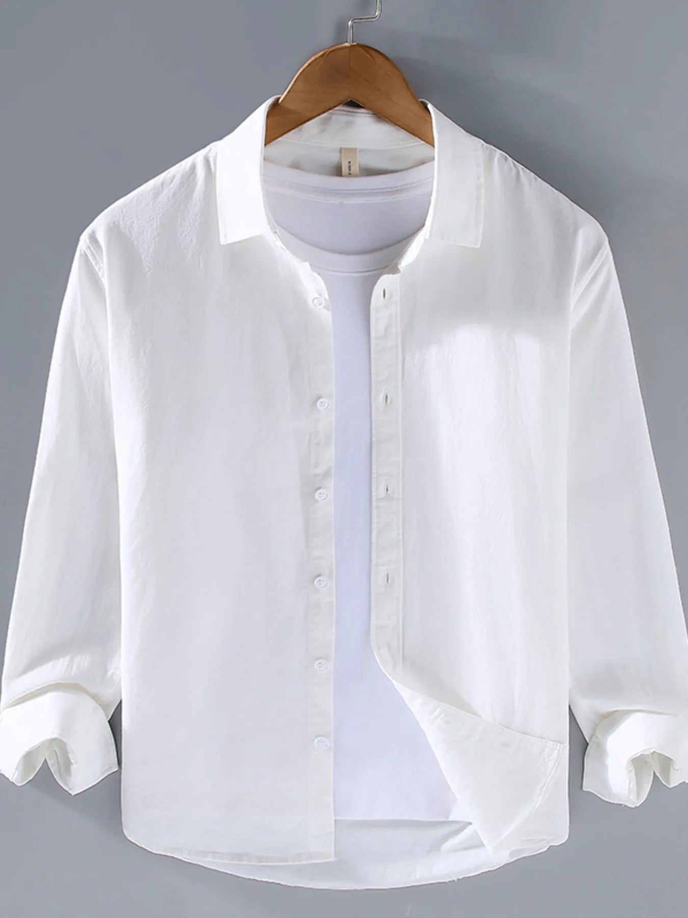 White button-up long sleeve shirt with pointed collar and front button placket.