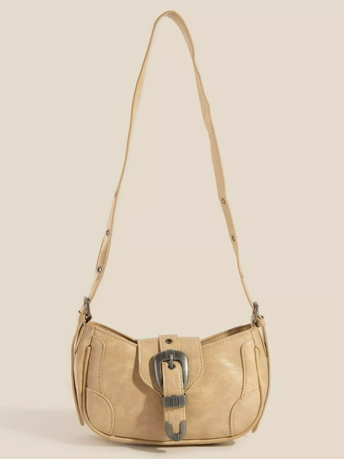 Tan multi-panel shoulder bag with buckle accent and adjustable strap.