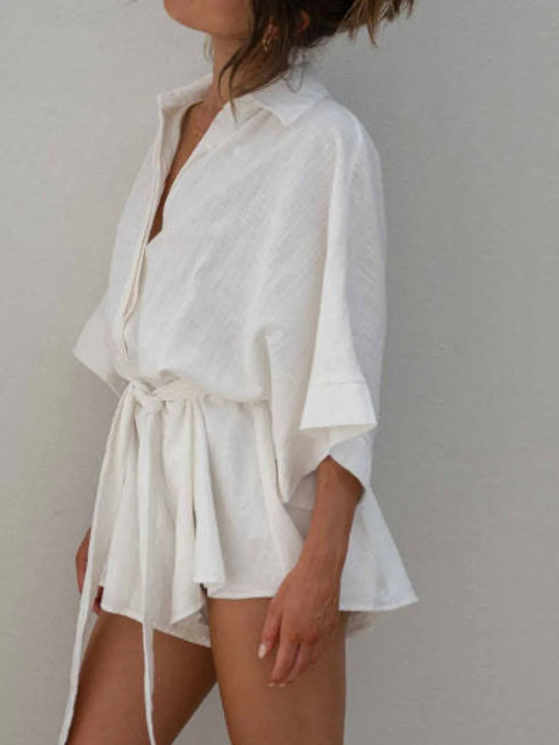 White collared half-sleeve romper with tied waist and flowing layered skirt