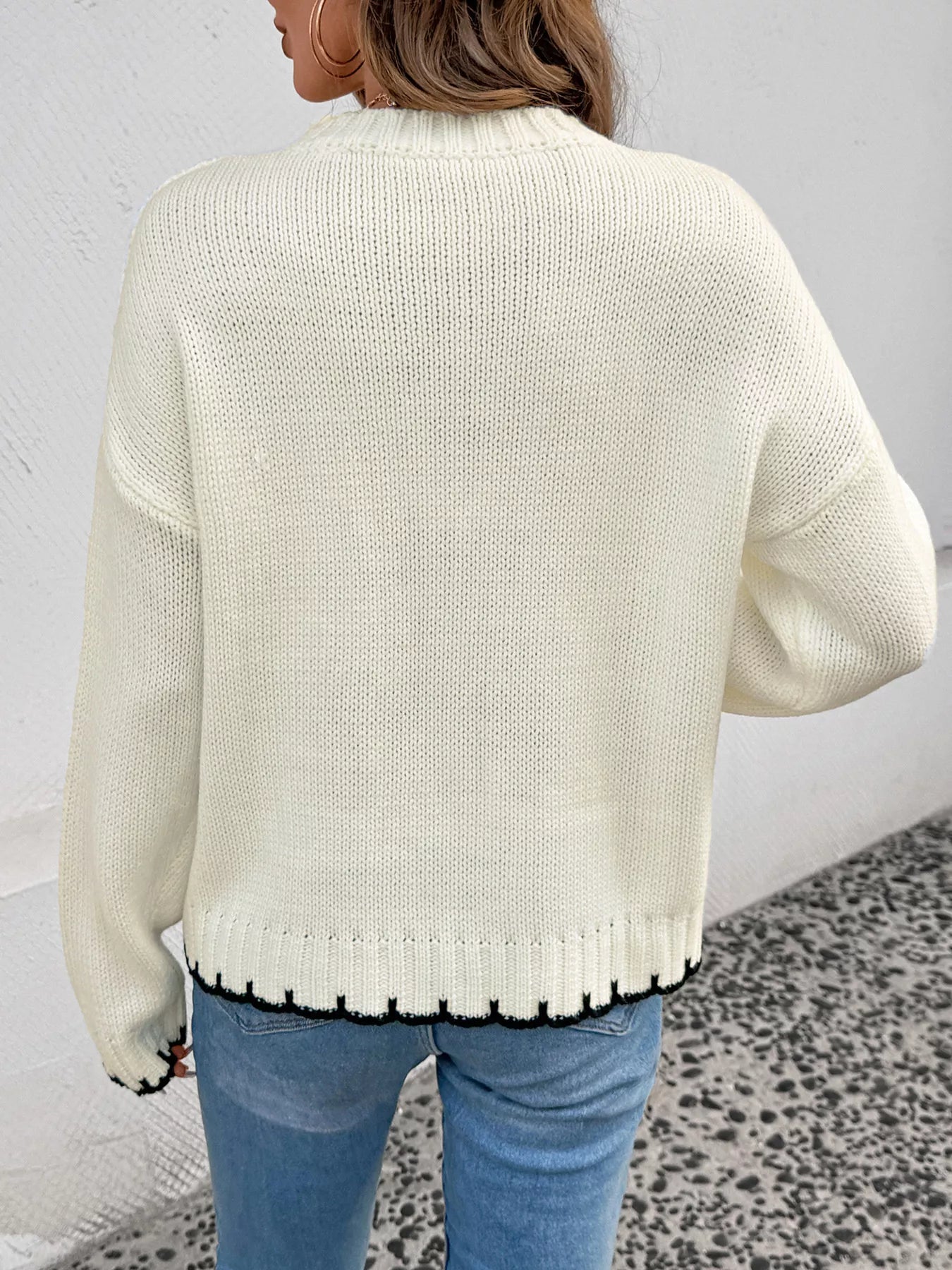 Ivory cable knit sweater back view with ribbed hem and relaxed shoulder seam