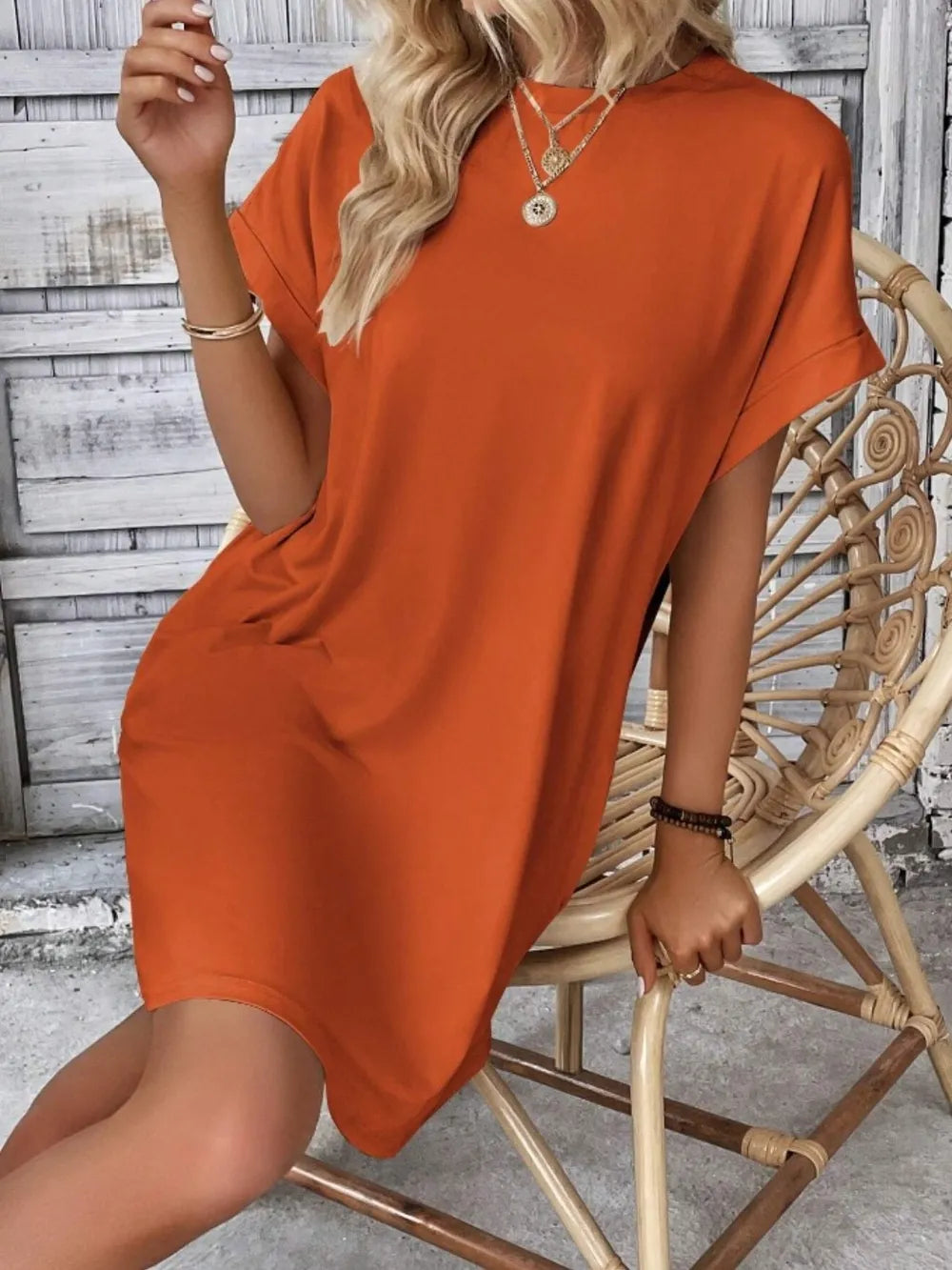Rust orange round-neck short-sleeve dress, back/side view with loose tunic hem