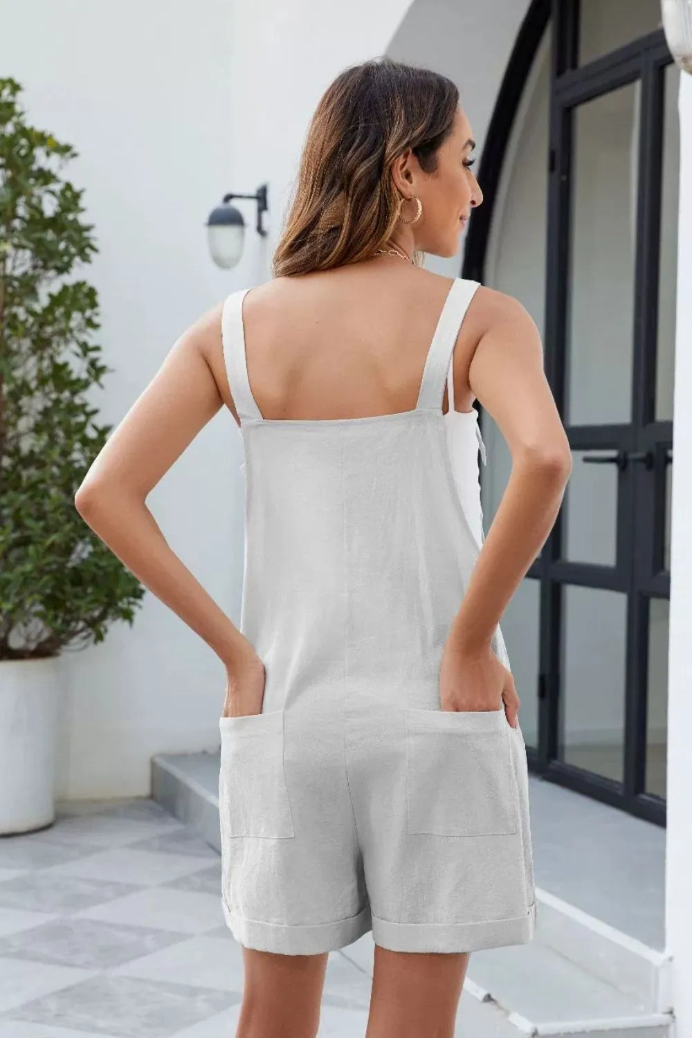 White romper with back yoke, knotted shoulder straps, and patch pockets