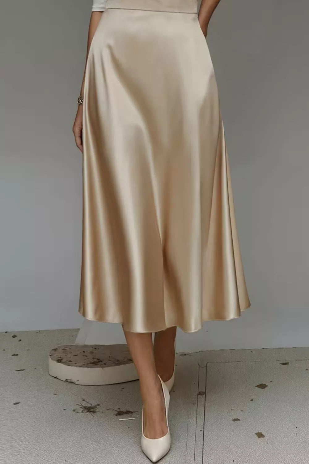 Satin A-line midi skirt in light gold with smooth drape and side pockets