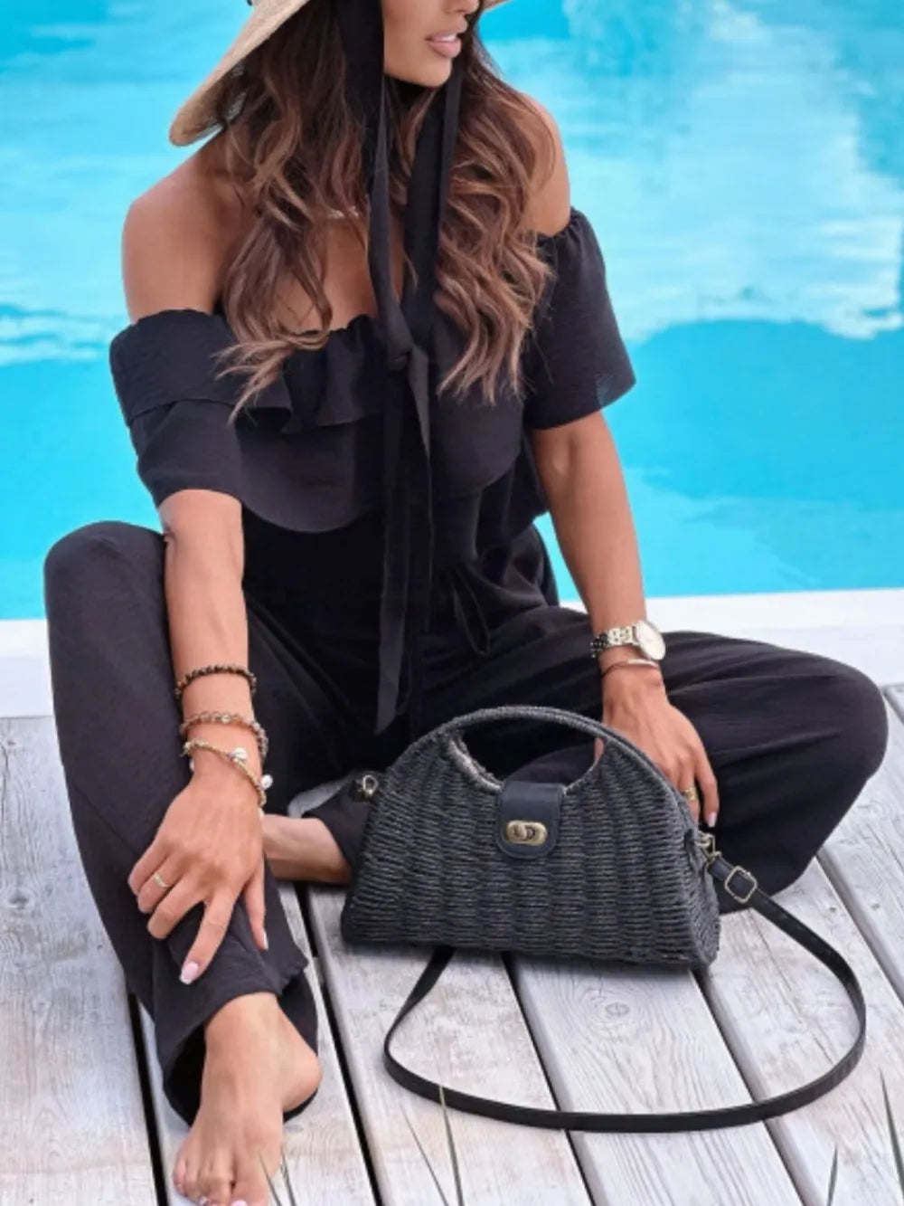 Black off-shoulder ruffled jumpsuit with tiered neckline and wide-leg silhouette