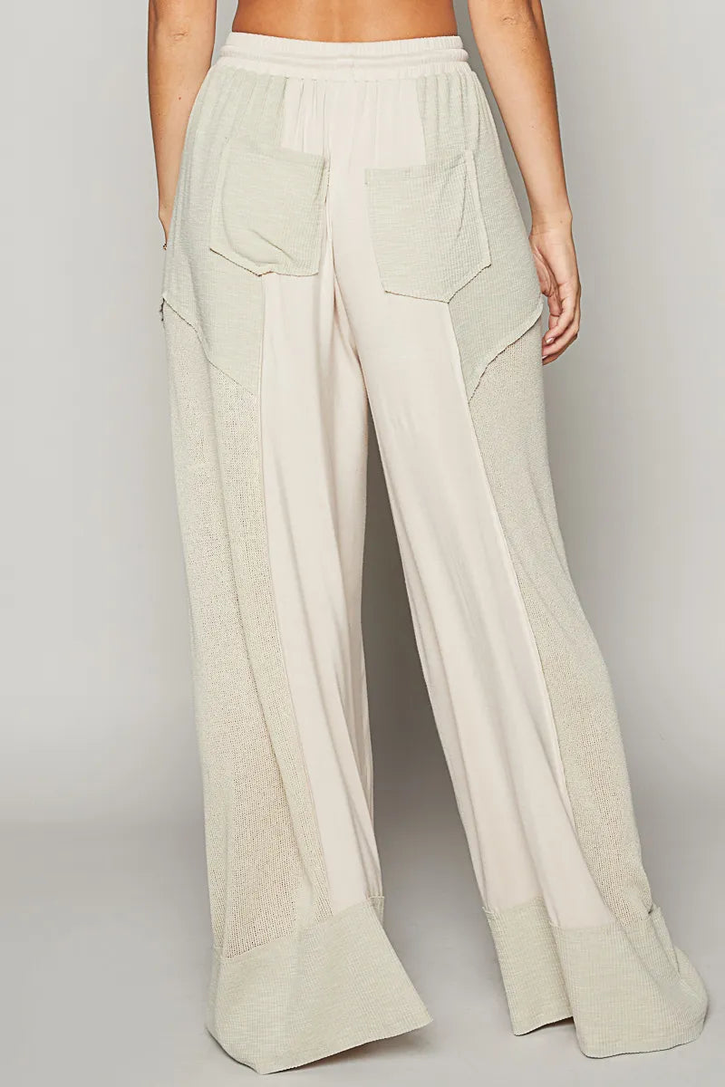 Cream wide-leg pants with elastic waist and two back patch pockets
