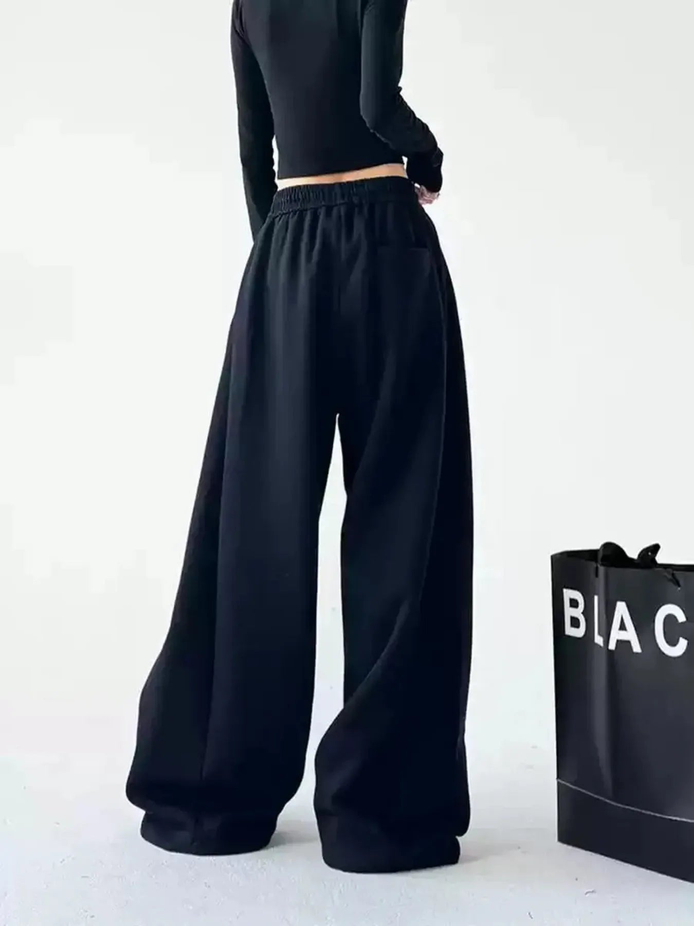 Dark oversized wide-leg drawstring pants with elastic waist and long wide silhouette
