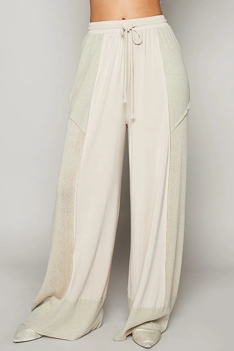 Cream wide-leg drawstring pants with elastic waist and side patch pockets