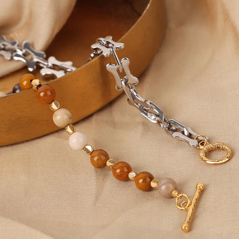 Beaded necklace with silver-tone chain, gold-tone clasp, and round stone beads on display