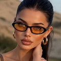 Black oval UV400 sunglasses with amber lenses and slim black frame, side arms