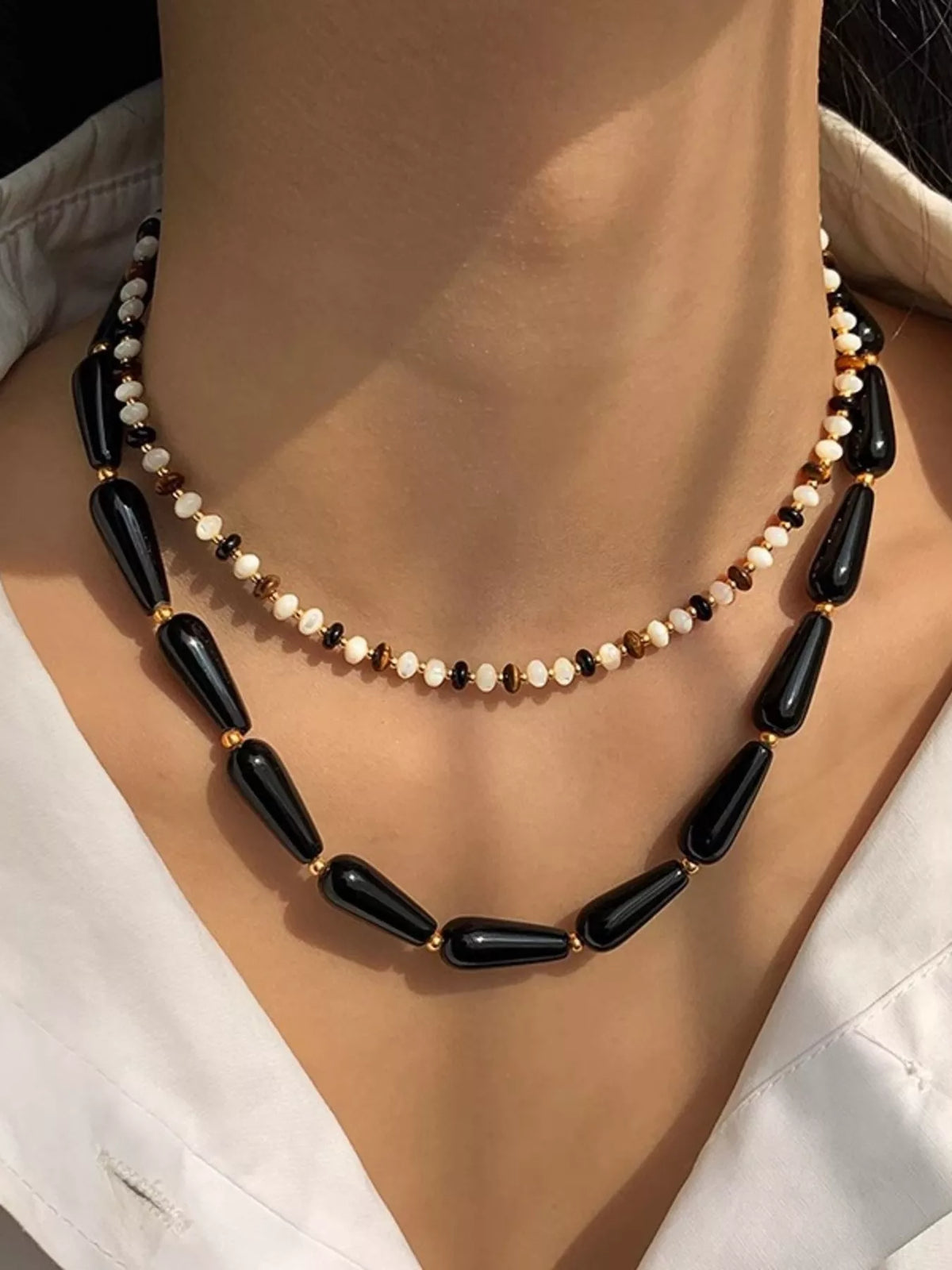 Black teardrop bead necklace with small round bead row and gold-tone chain
