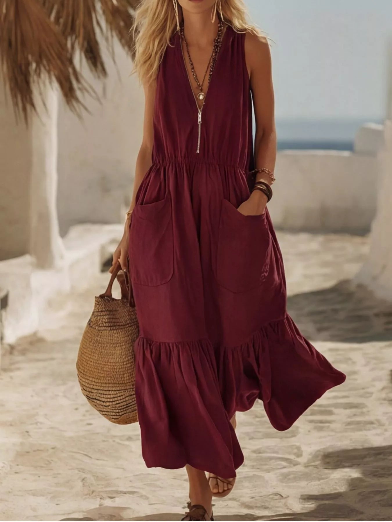 Burgundy sleeveless maxi dress with zipper front, pockets, and ruffle hem