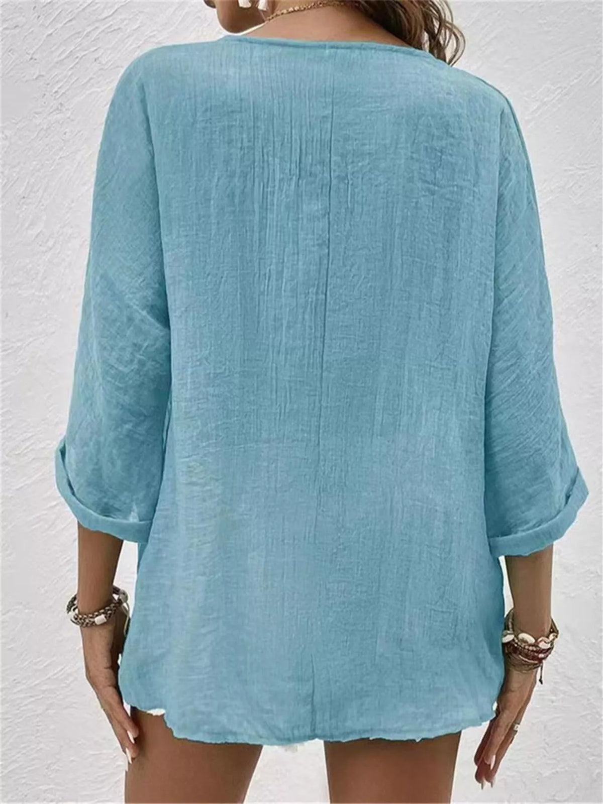 Back view of blue V-neck button blouse with 3/4 sleeves and relaxed fit