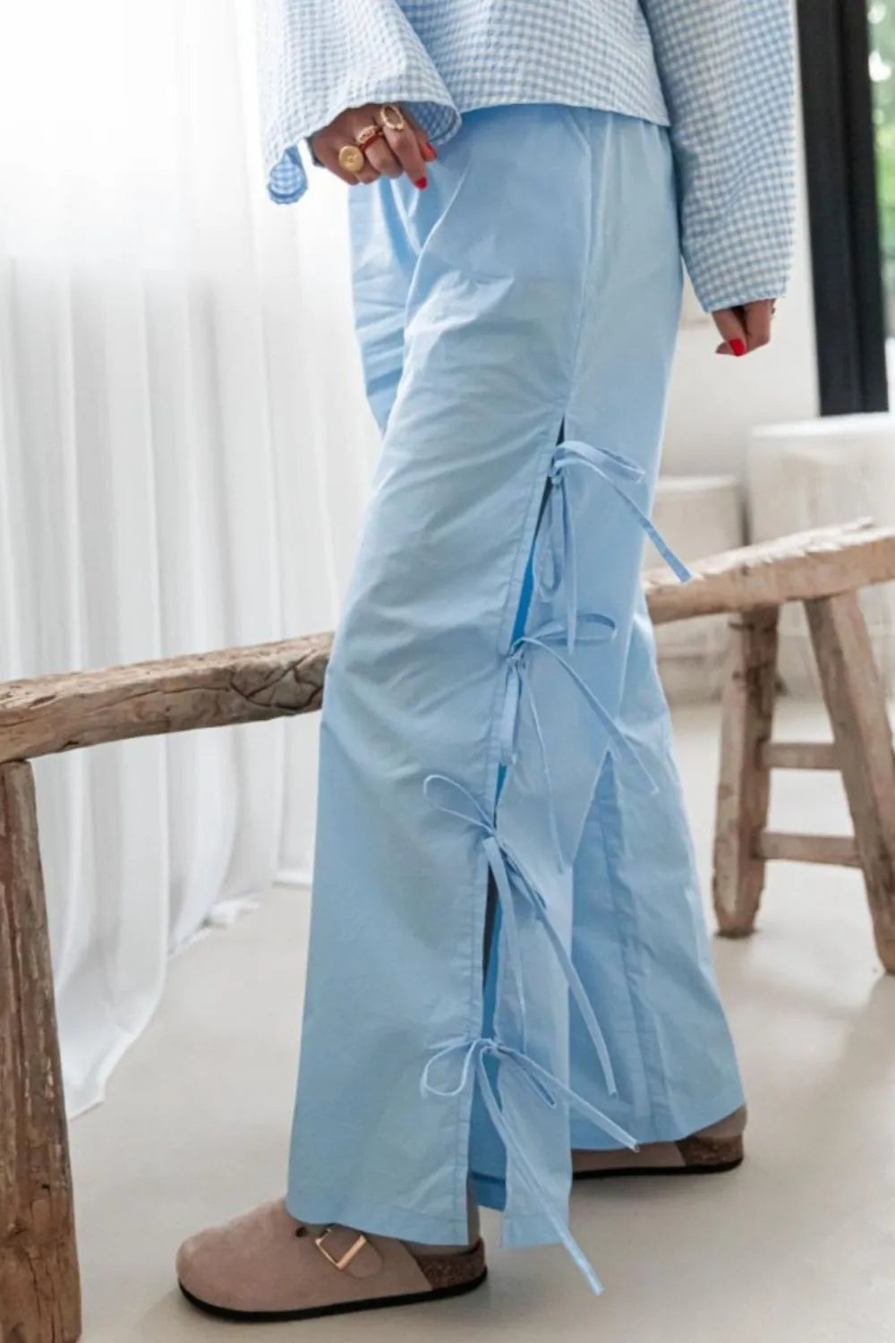 Light blue wide-leg pants with side ties and pocket-style drape