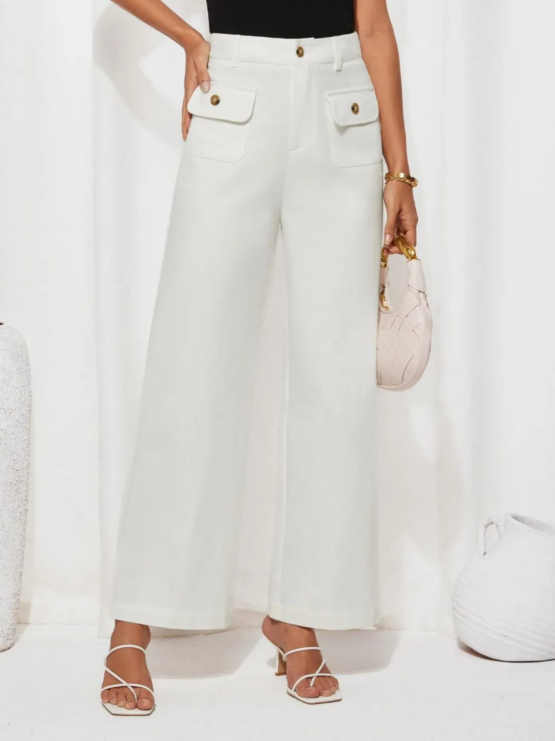 White high-waist wide-leg pants with front patch pockets and gold button closures