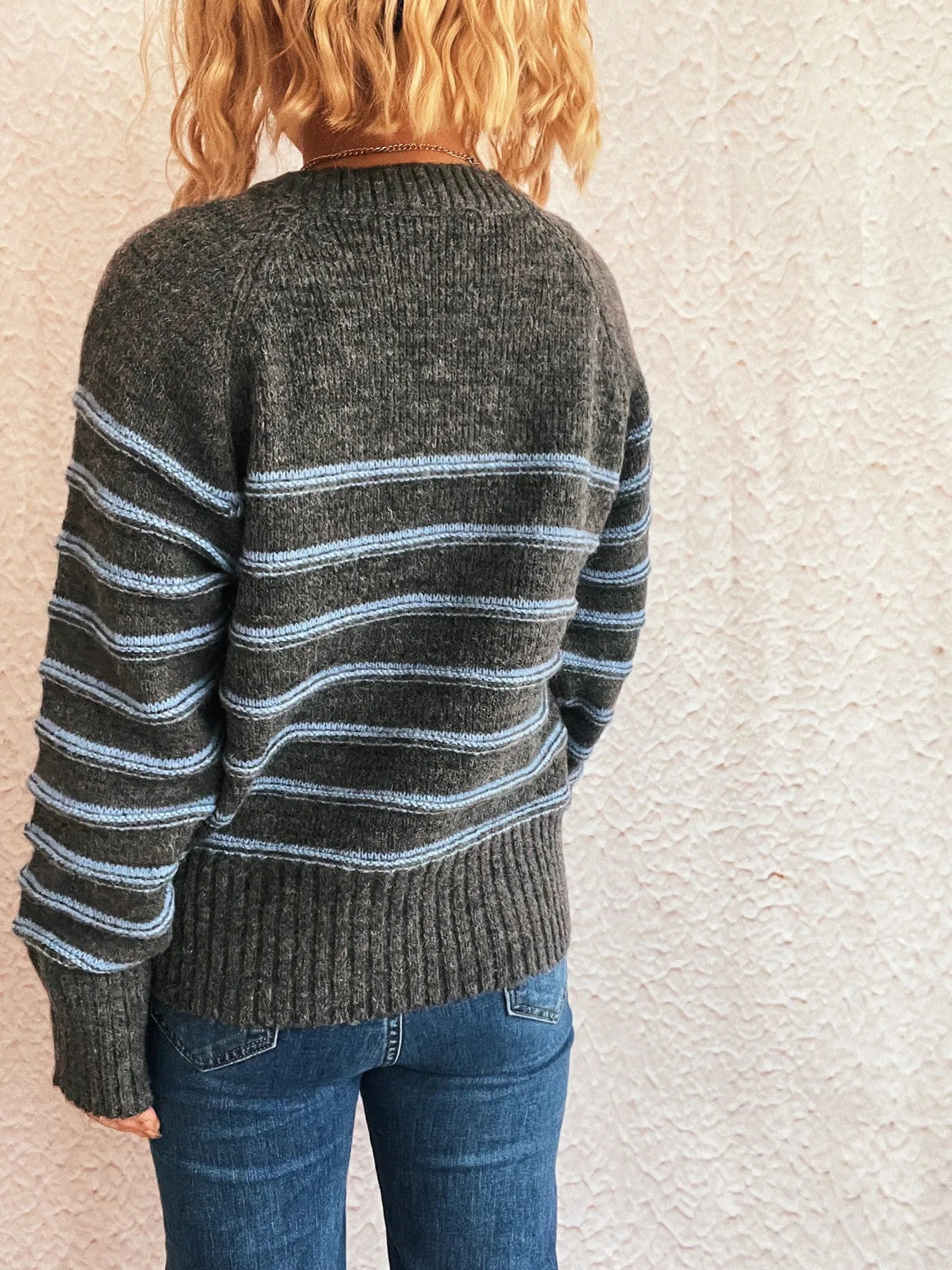 Back view dark gray striped long sleeve sweater with ribbed knit cuffs and hem