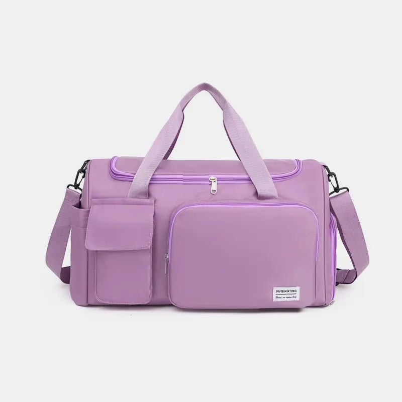 Large travel duffle bag with detachable straps, purple front panel and side handles.