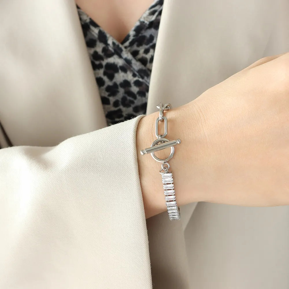 Silver-tone closure bracelet with bar-and-ring charms and rhinestone detail