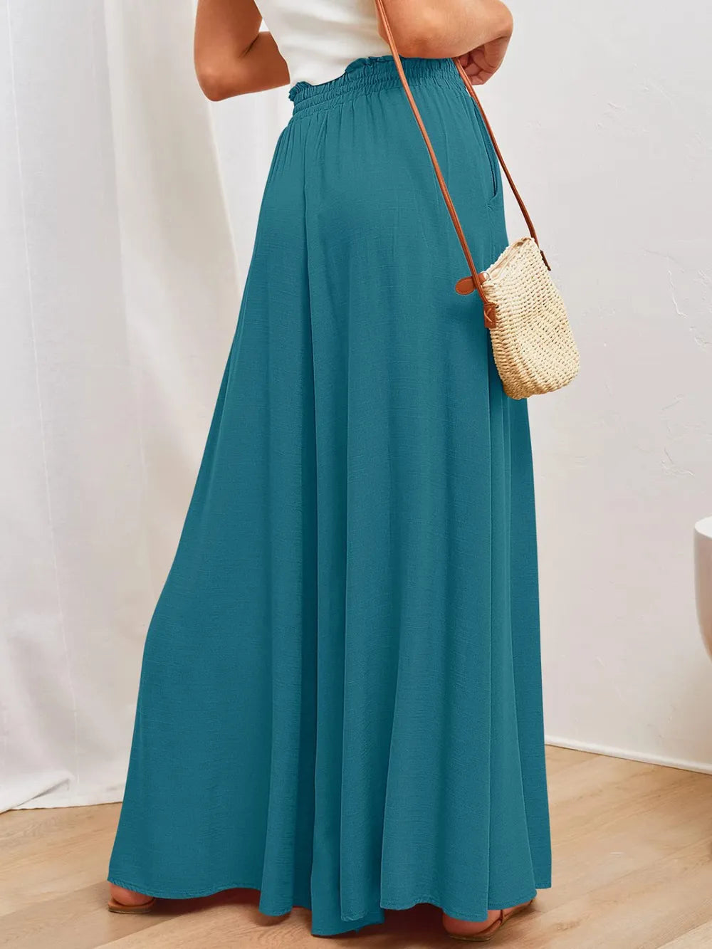 Teal wide-leg pants with elastic waist and side pockets, shown from the side