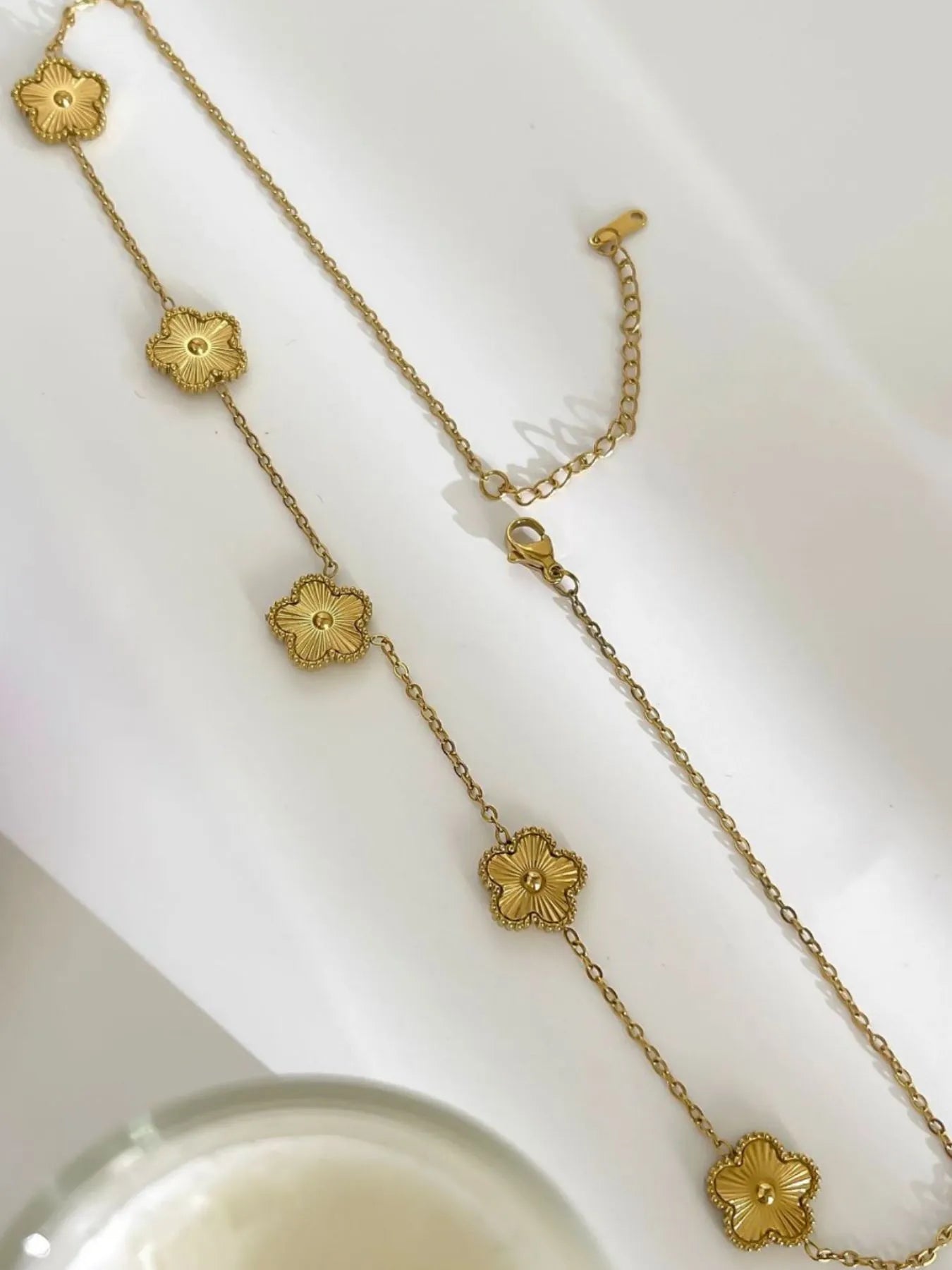Gold-plated flower chain necklace with five dangling flower charms and clasp loop