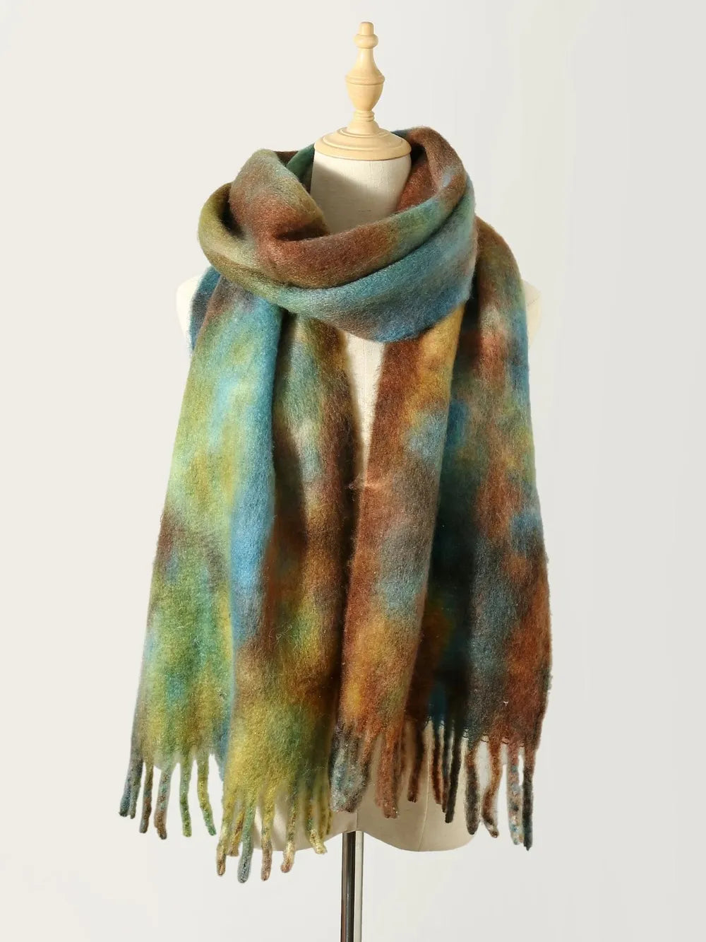 Tie-dye polyester scarf with fringe, teal and olive-brown tones, draped on mannequin
