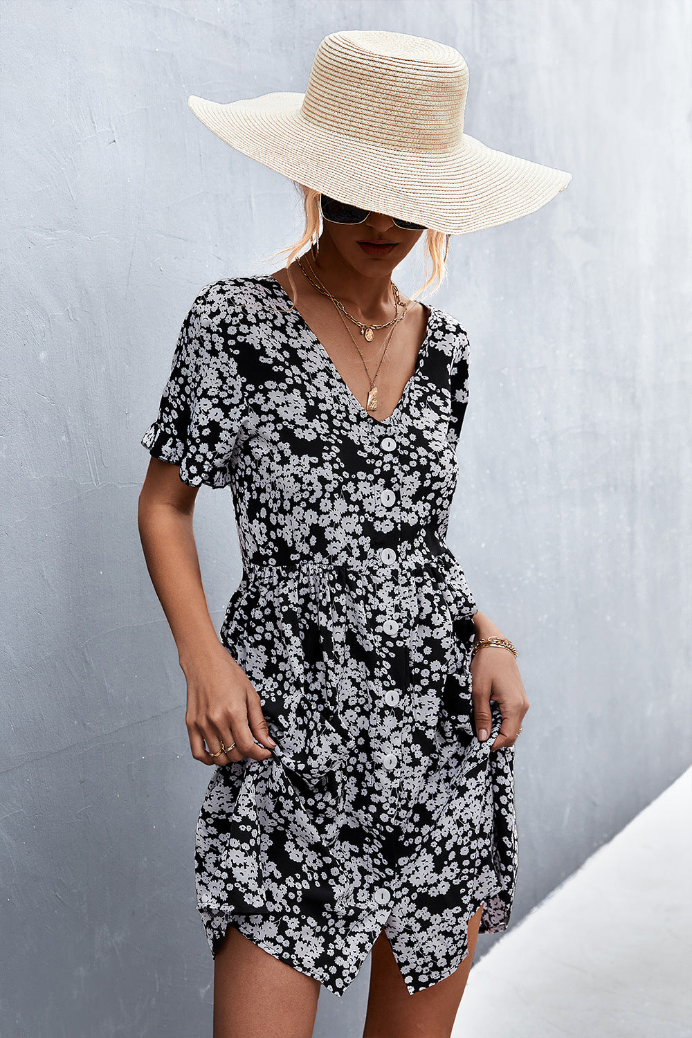 Black floral printed button-front dress with V-neck, short sleeves, and patch pockets.