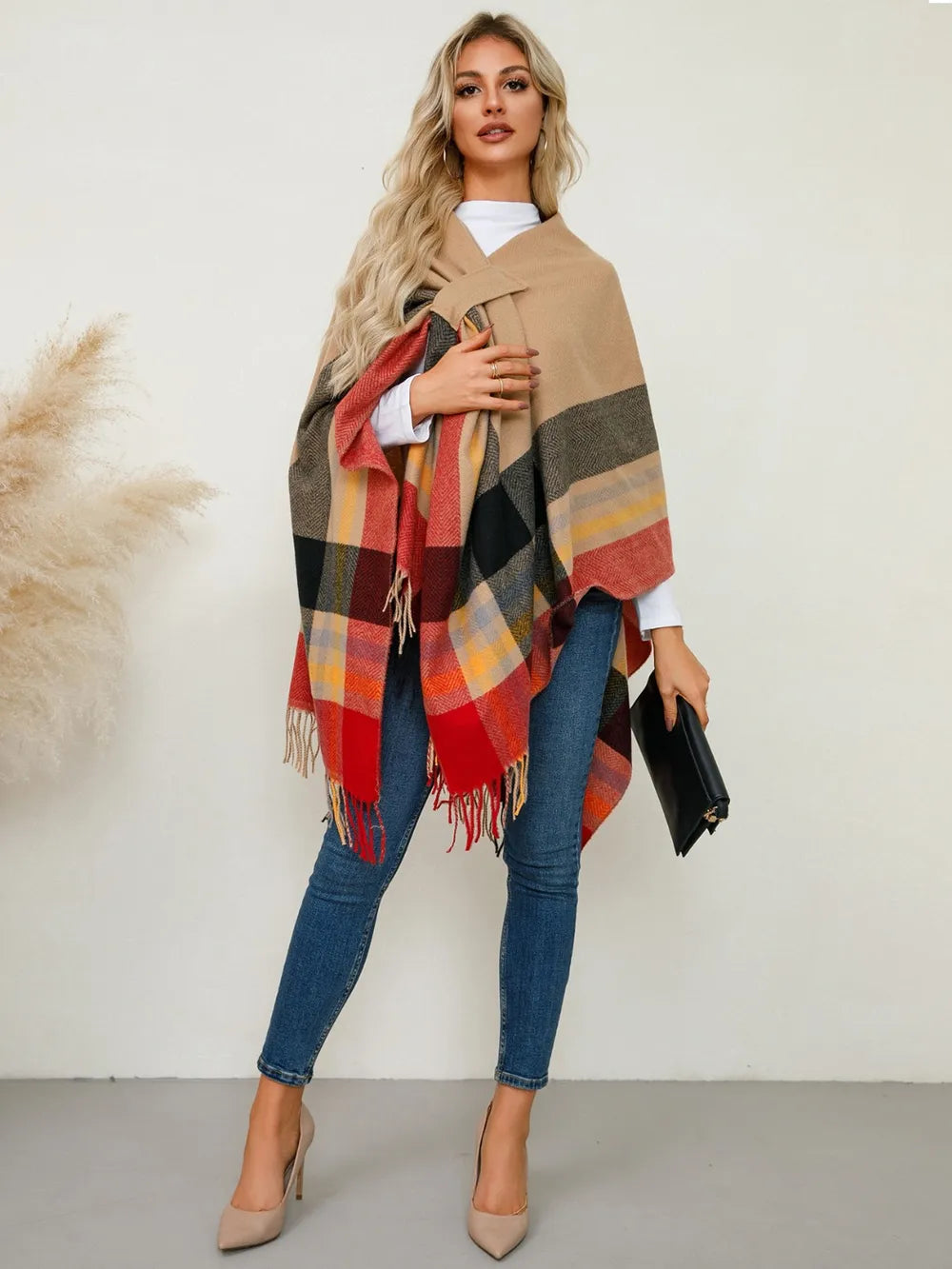 Plaid contrast poncho with fringe trim, tan color with black and red checked stripes