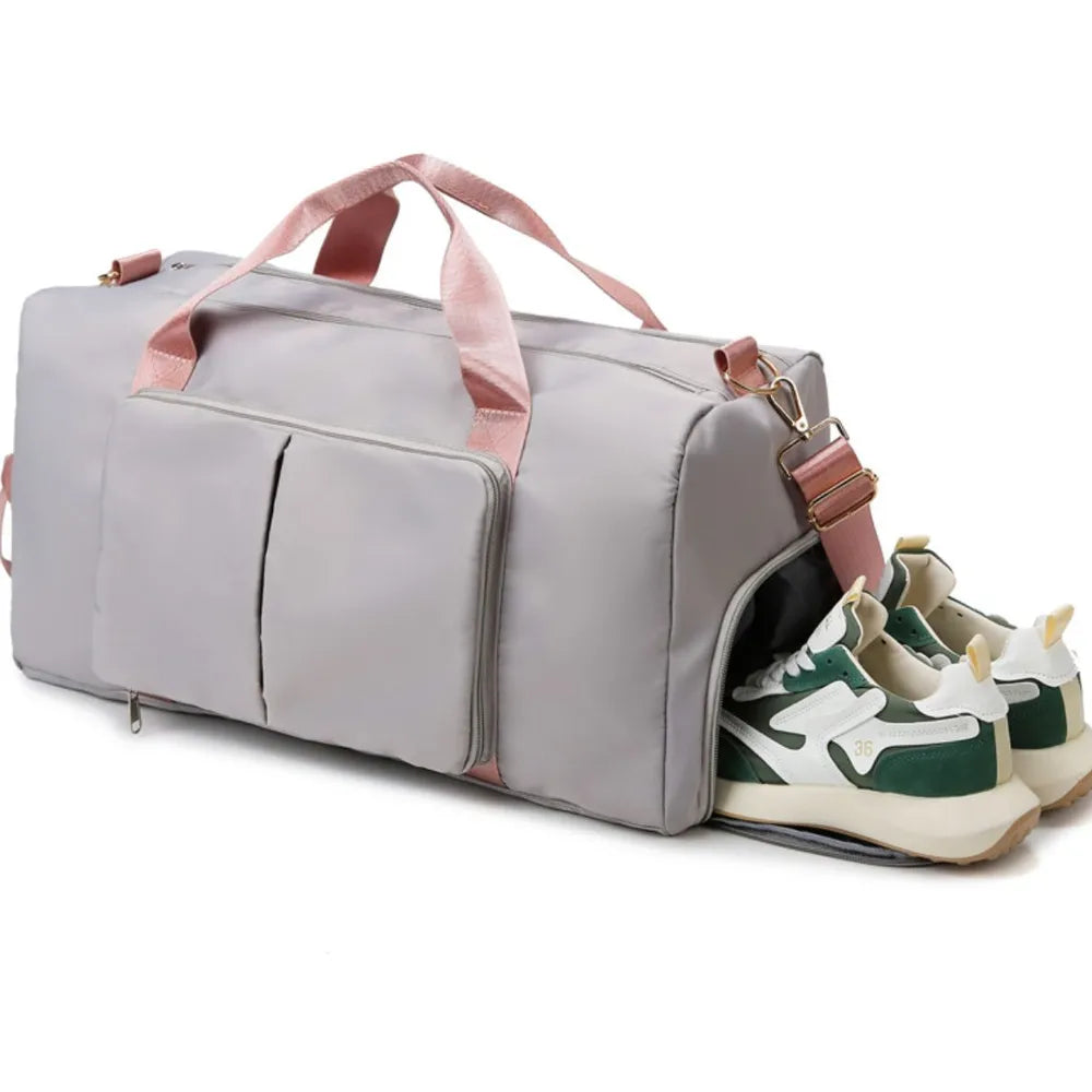 Large travel duffel bag with front zip pocket, light gray body, pale pink handles