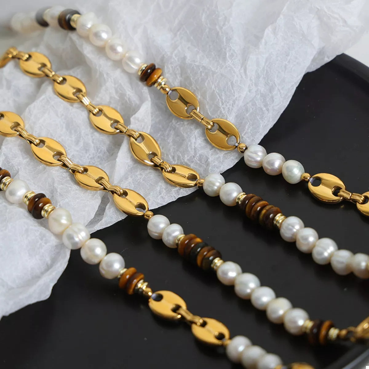Layered freshwater pearl and tiger eye bead necklaces with gold oval links
