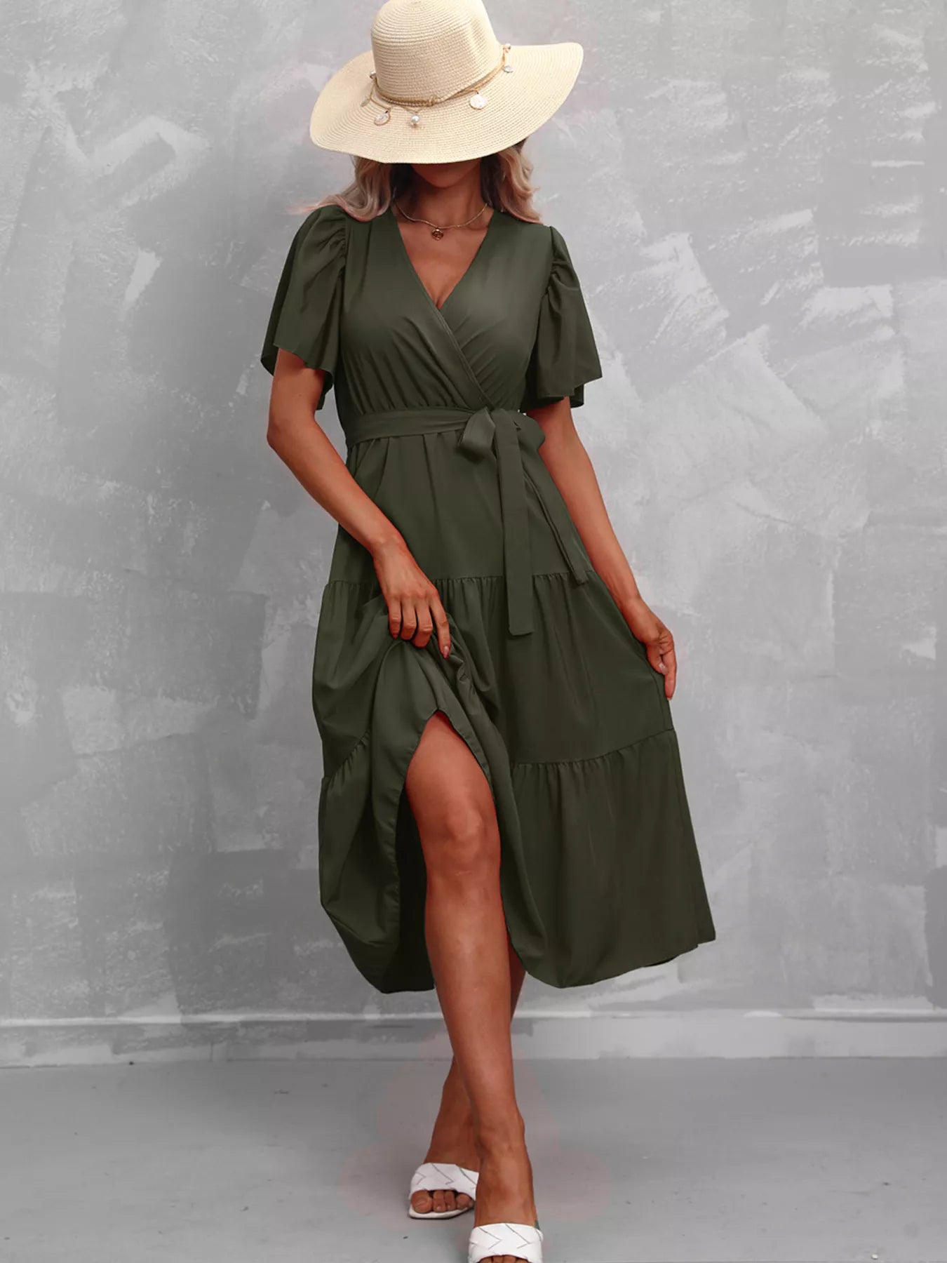 Deep green tiered midi dress with V-neck, flutter sleeves, tie waist belt, side slit