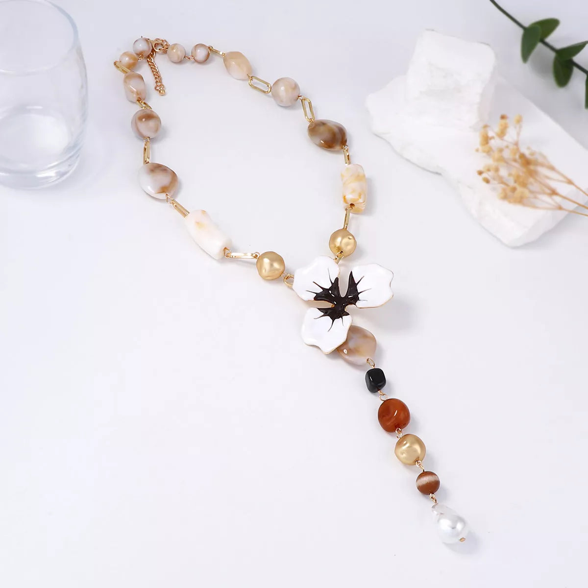 Y-shaped flower resin necklace with white petals, black center, and multicolor bead chain