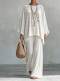 White velvet wide-leg pants set with loose asymmetrical poncho-style top