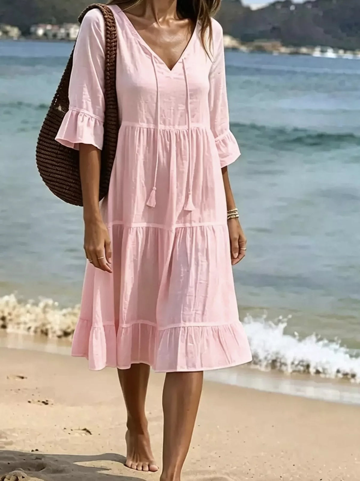 Blush pink tiered tie-neck flounce sleeve dress with tassel strings, knee-length