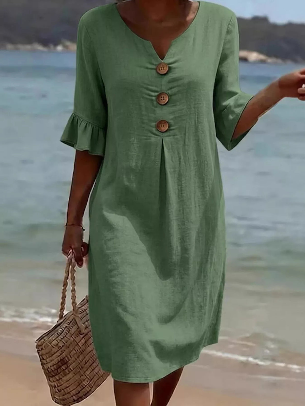 Green button-front dress with ruffle sleeves and center pleat detail