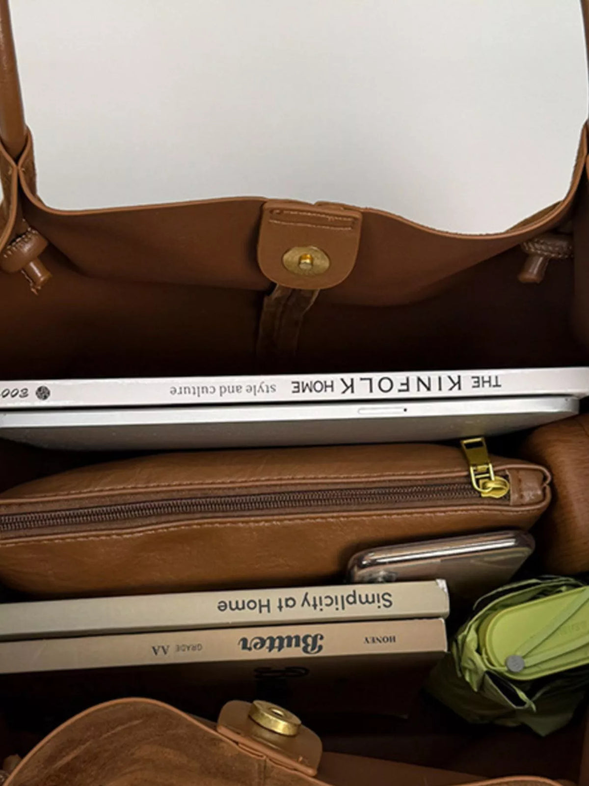Brown suede tote bag interior showing zipper pocket and gold-toned clasp